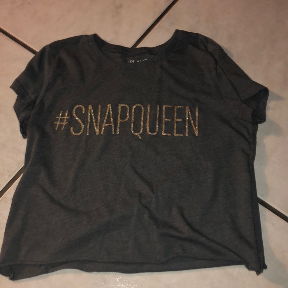 It’s a dark gray crop top that says  #SNAPQUEEN⚡️
